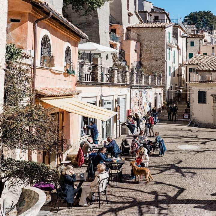 emberek ülnek a székek barna beton épület közelében csúszó puzzle online