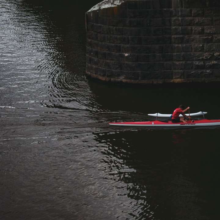 osoba w czerwonym kajaku na zbiorniku wodnym w ciągu dnia puzzle online
