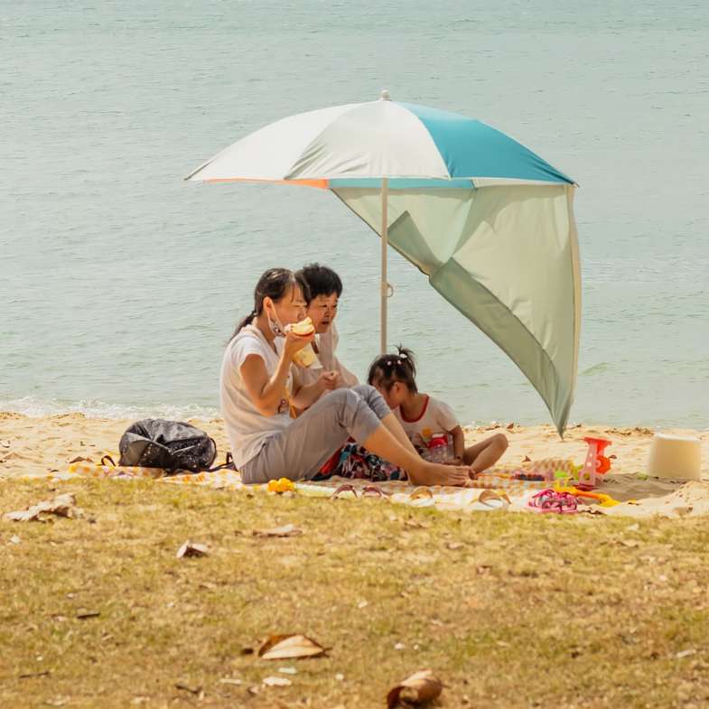 2 women sitting on beach sand during daytime online puzzle