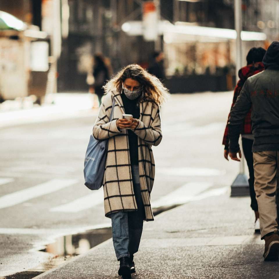 kvinna i vit och svart kappa som går på trottoaren glidande pussel online