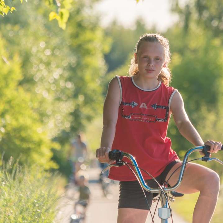 κορίτσι με κόκκινο φανελάκι ιππασία με ποδήλατο κατά τη διάρκεια της ημέρας συρόμενο παζλ online