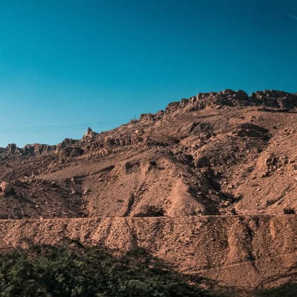 bruine rotsachtige berg onder de blauwe hemel overdag schuifpuzzel online