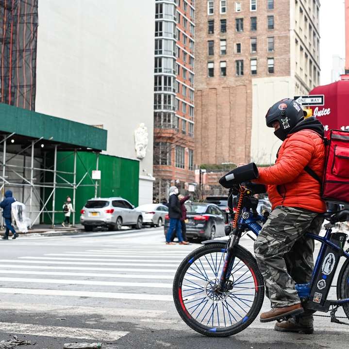 Mann in der blauen Jacke, die blaues Motorrad auf Straße fährt Schiebepuzzle online