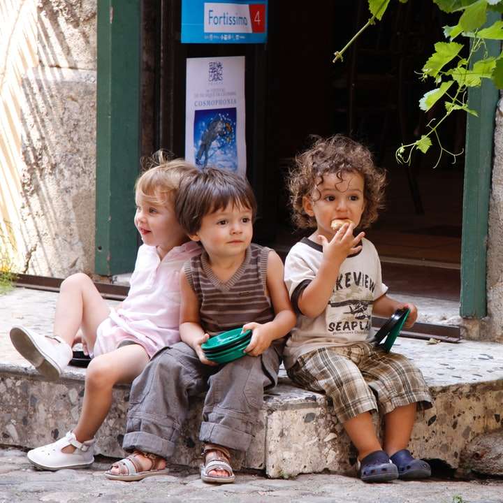 2 chłopców i dziewczynka siedzą na betonowej ławce puzzle online