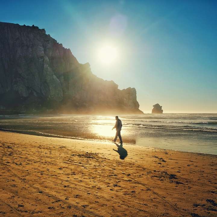 човек в черна риза и панталон, разхождащ се на плажа онлайн пъзел