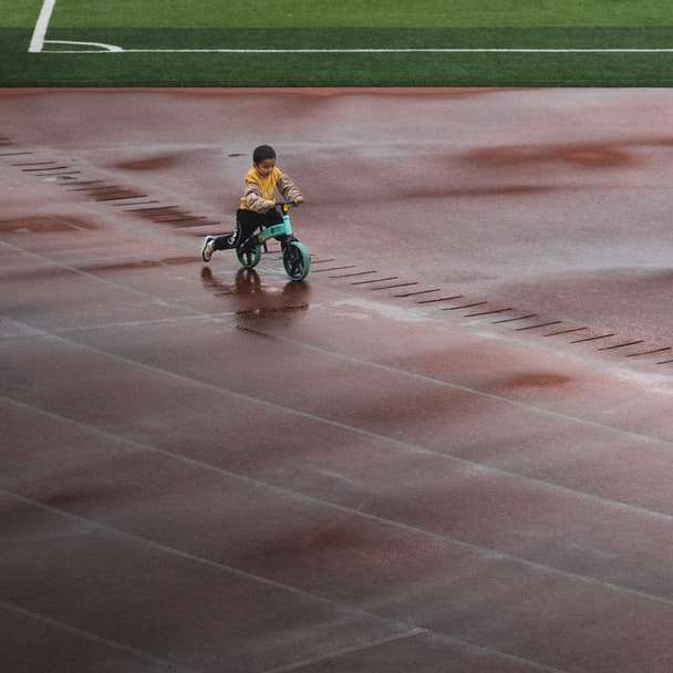Мальчик в синей рубашке катается на велосипеде по легкой атлетике онлайн-пазл