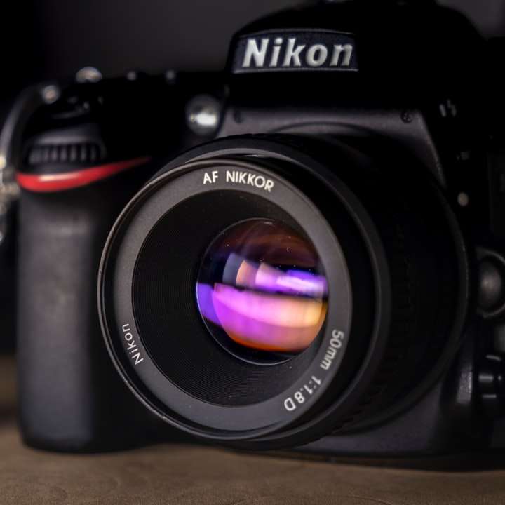 Appareil photo reflex numérique Nikon noir sur table en bois marron puzzle coulissant en ligne