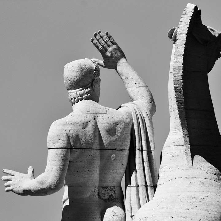 Foto en escala de grises del hombre que sostiene la estatua de la botella de vidrio rompecabezas en línea