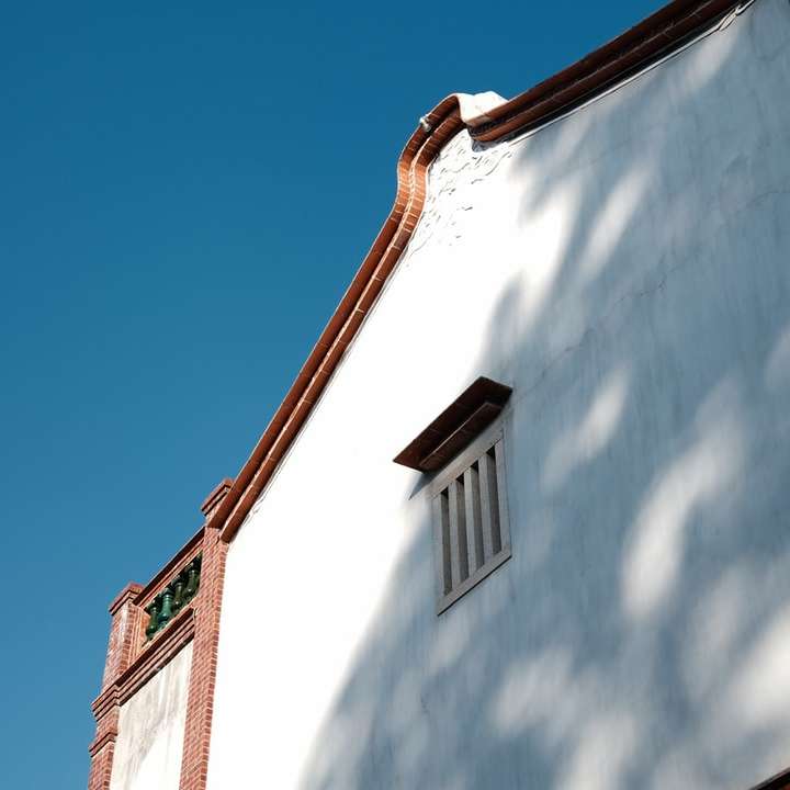 бяла и кафява бетонна сграда под синьо небе онлайн пъзел