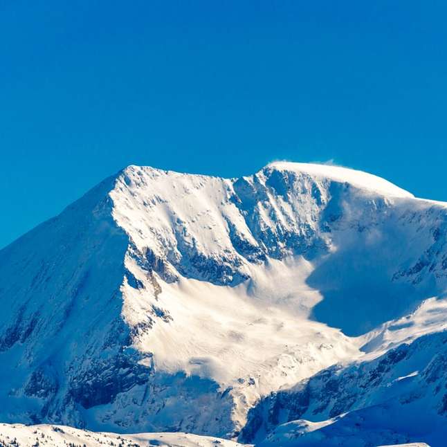 pokryte śniegiem góry pod błękitnym niebem w ciągu dnia puzzle przesuwne online