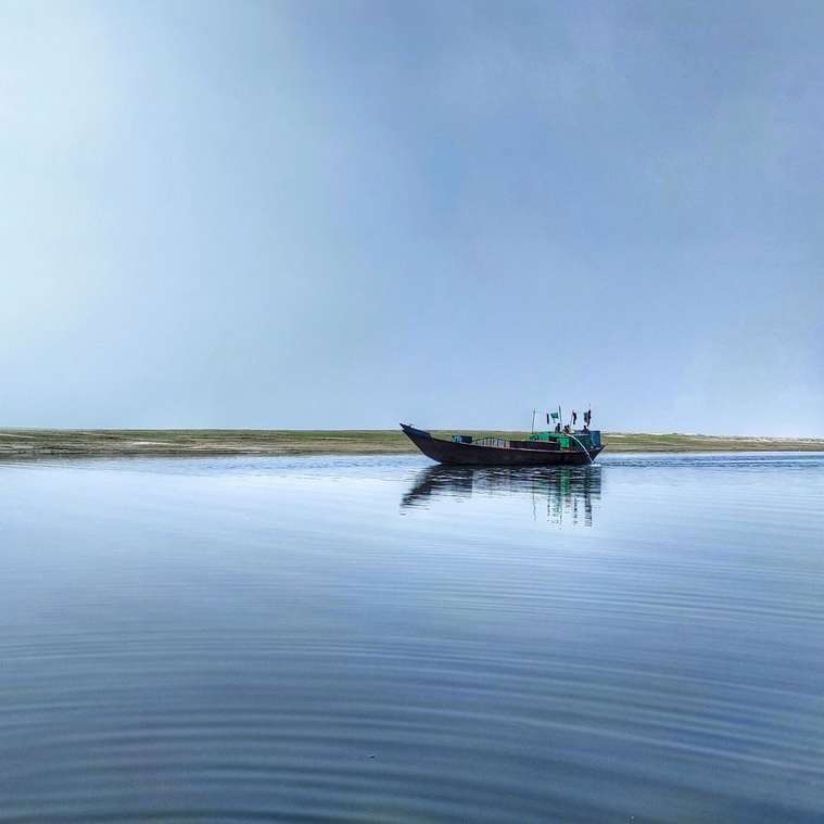 лодка в море под серым небом онлайн-пазл