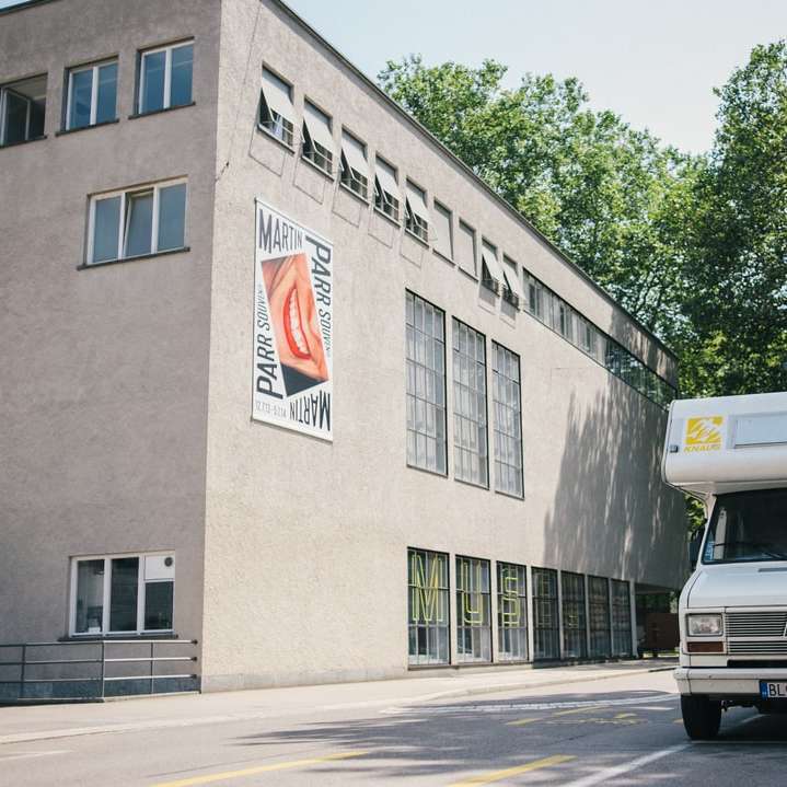 furgone Ford bianco parcheggiato accanto a un edificio di cemento grigio puzzle scorrevole online
