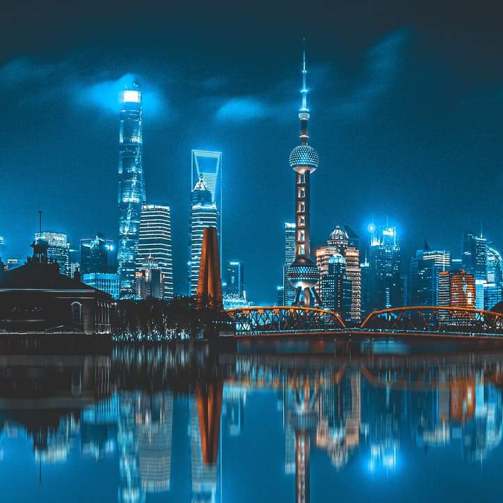 skyline della città attraverso lo specchio d'acqua durante la notte puzzle scorrevole online