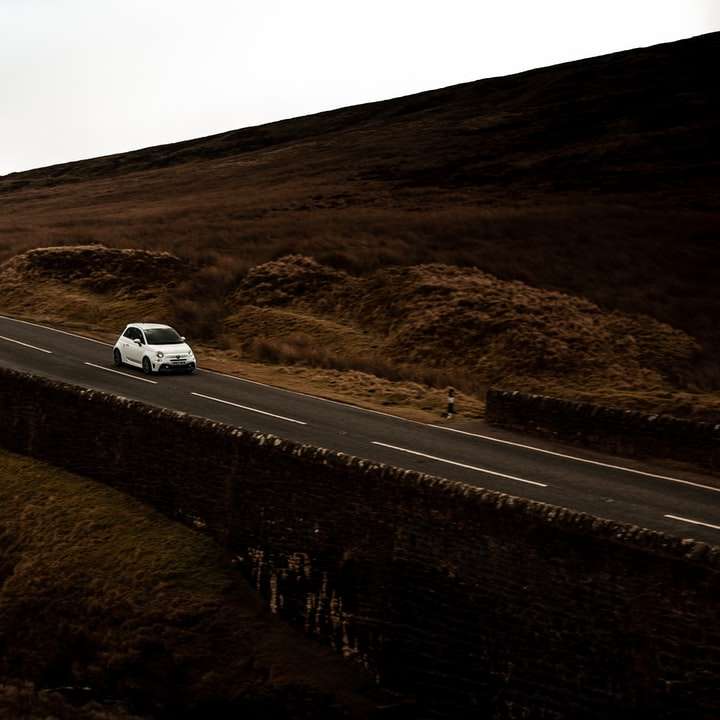 biały samochód na drodze w ciągu dnia puzzle przesuwne online