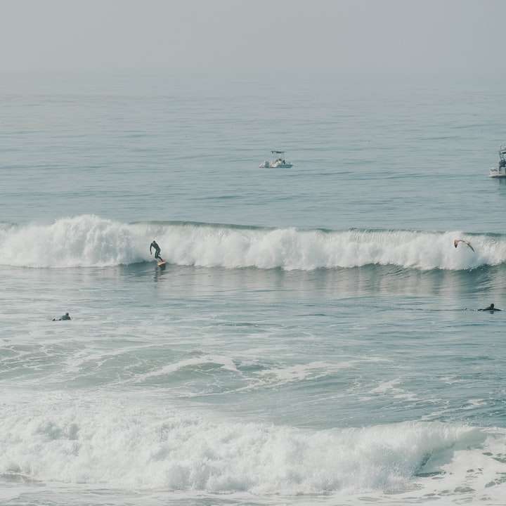människor som surfar på havsvågor under dagtid Pussel online