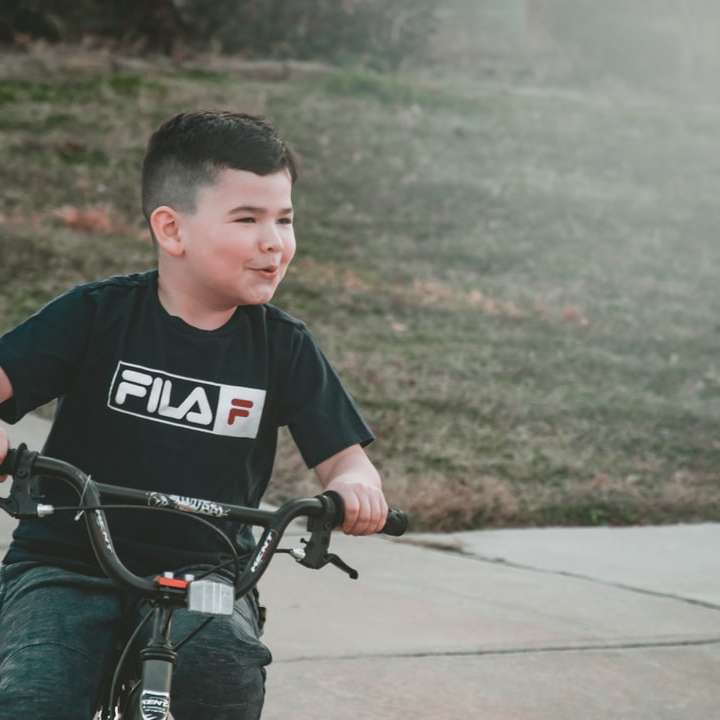 jongen in zwart-wit t-shirt met ronde hals rijden schuifpuzzel online