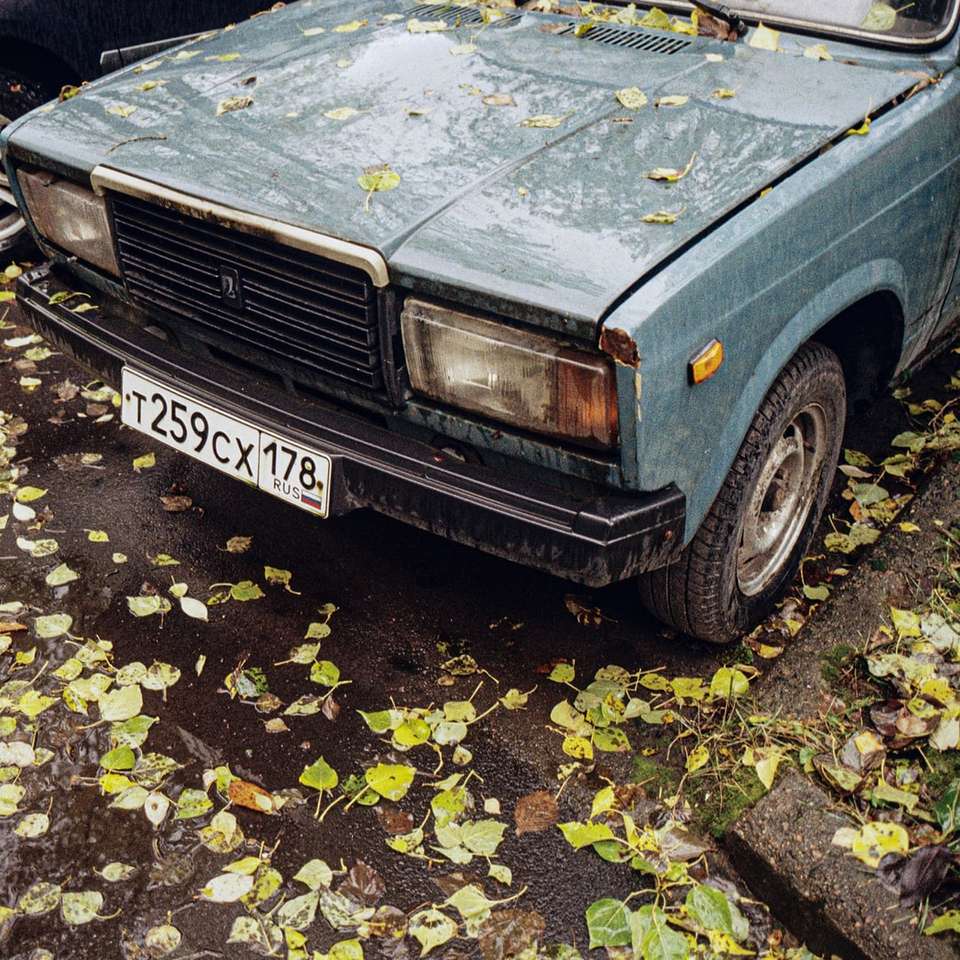 μπλε αυτοκίνητο με κίτρινα φύλλα στο έδαφος συρόμενο παζλ online