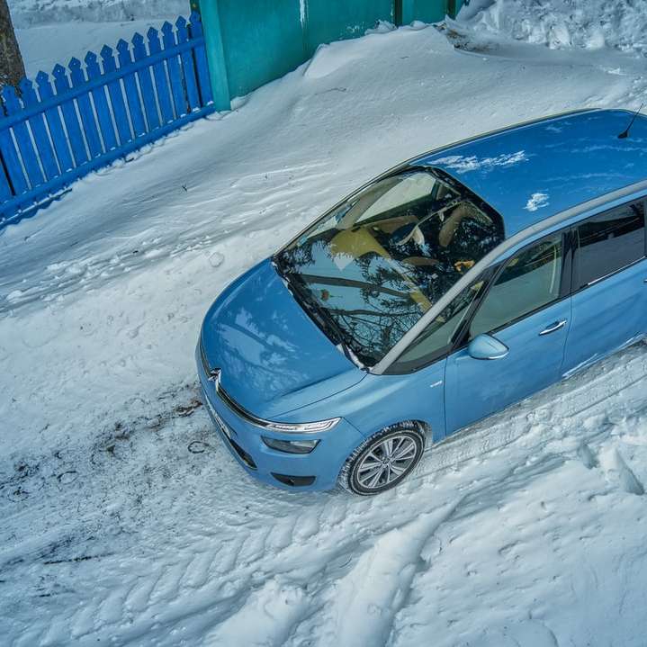 blaues 5-türiges Fließheck auf schneebedeckter Straße während des Tages Schiebepuzzle online