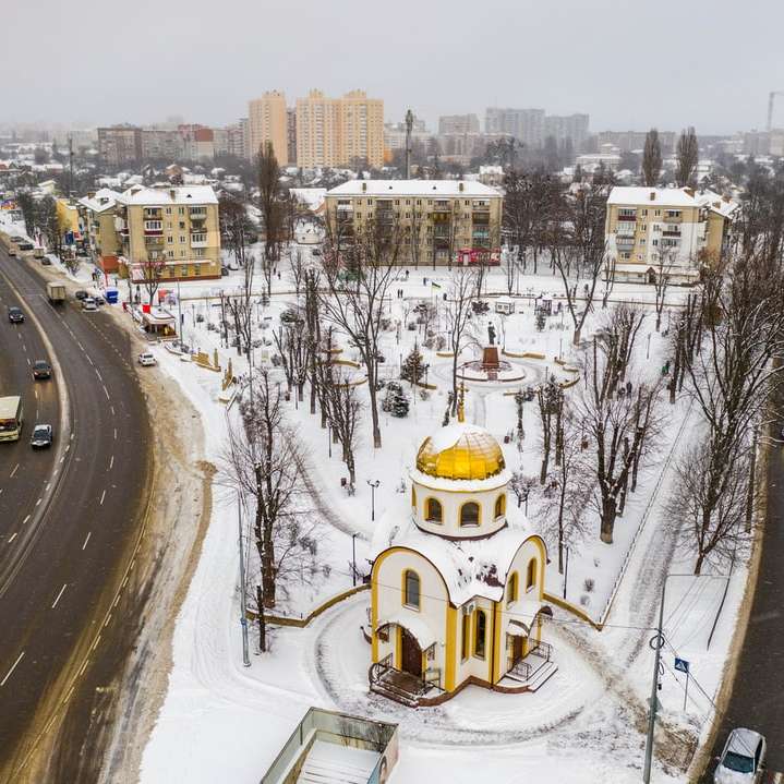 żółty i biały betonowy budynek na ziemi pokrytej śniegiem puzzle przesuwne online