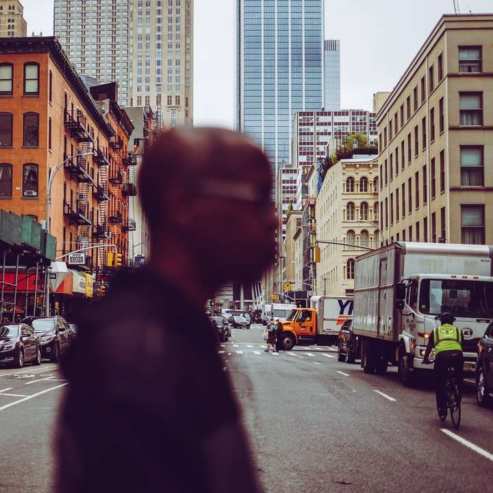 mężczyzna w czarnej kurtce stojący na chodniku w ciągu dnia puzzle przesuwne online