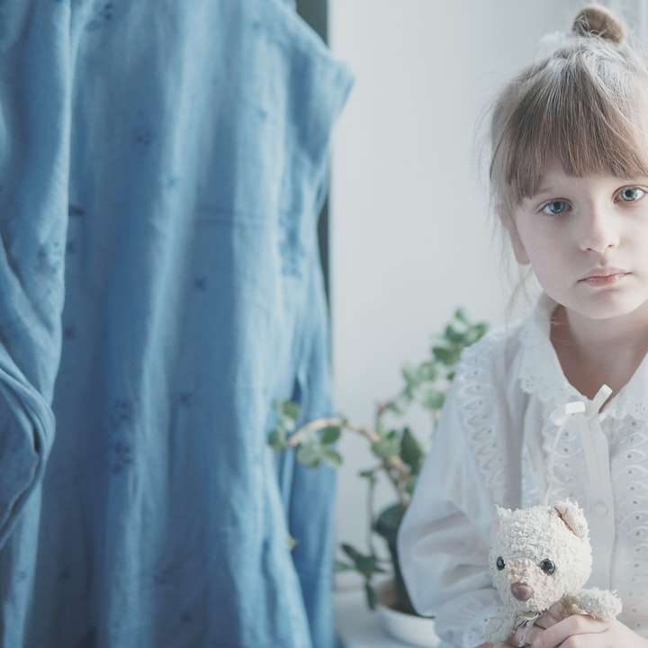 fată în rochie albă care deține jucărie de pluș urs alb alunecare puzzle online