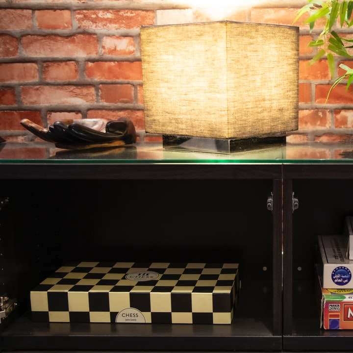 Lampe de table marron et noire sur étagère en bois noir puzzle coulissant en ligne