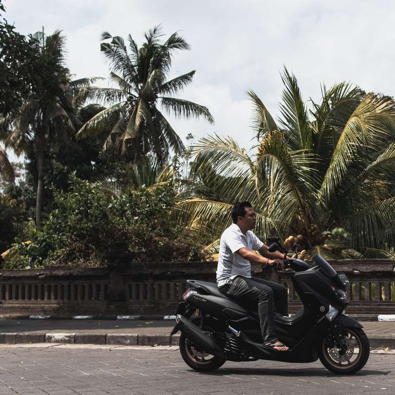 Mann im weißen Hemd reitet schwarzes Motorrad auf Straße Online-Puzzle