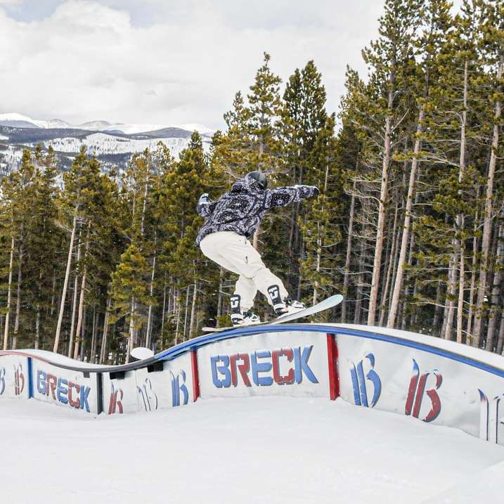man in black jacket riding on snowboard during daytime sliding puzzle online