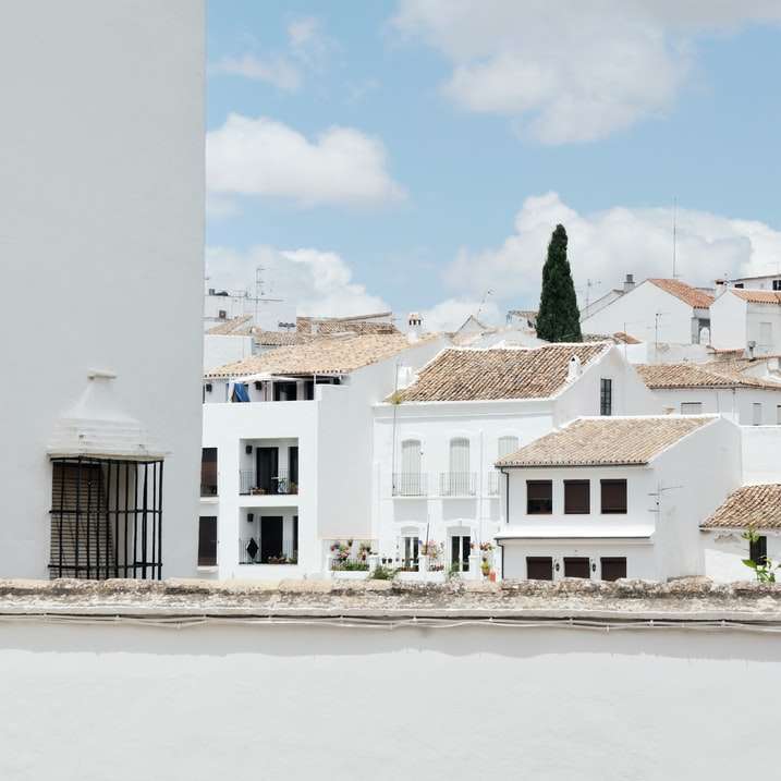 бяла и кафява бетонна къща под синьо небе през деня онлайн пъзел
