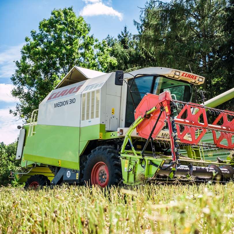 червено и жълто тежко оборудване на полето със зелена трева онлайн пъзел