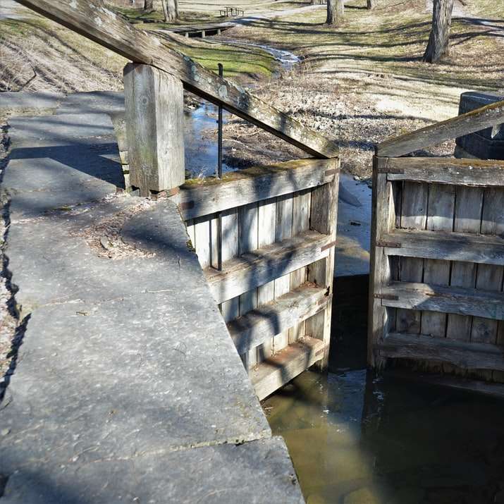 bacino di legno marrone sul fiume durante il giorno puzzle scorrevole online
