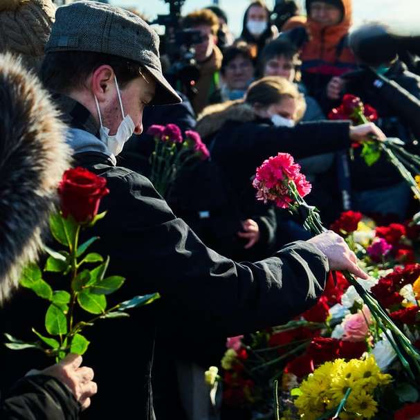 homem de terno preto segurando um buquê de flores puzzle online