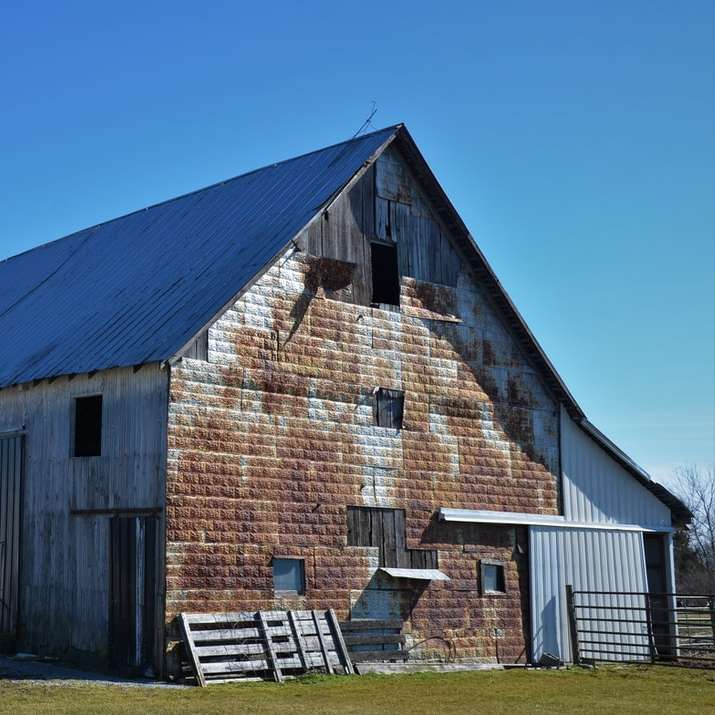 brązowa drewniana stodoła pod błękitnym niebem w ciągu dnia puzzle online