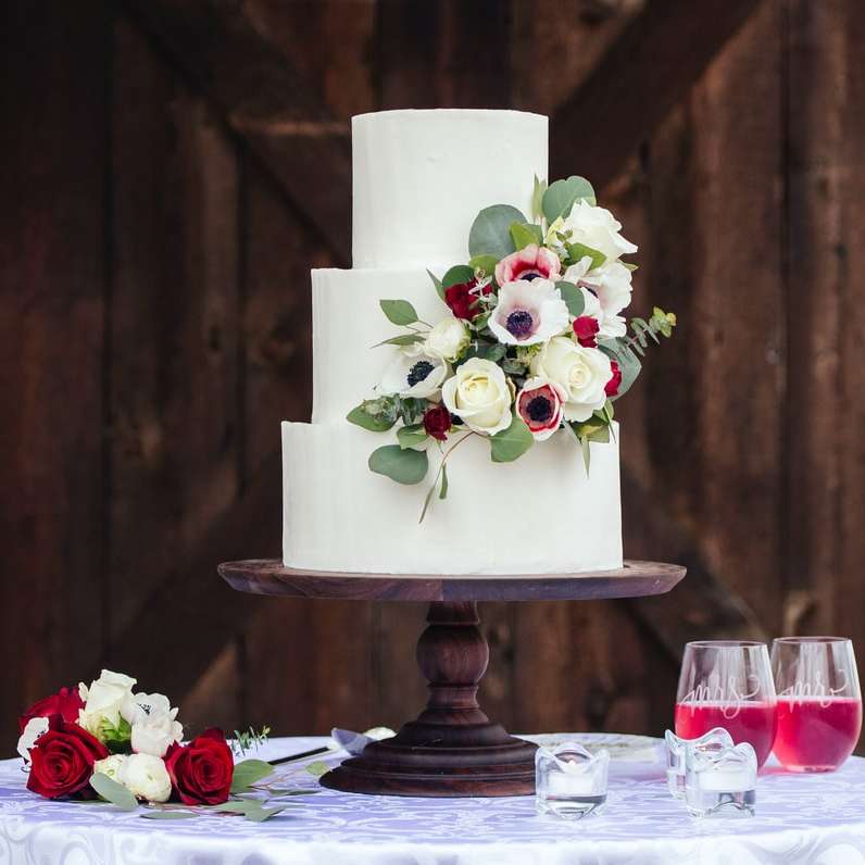 vita och röda rosor på vit kaka med tre nivåer Pussel online