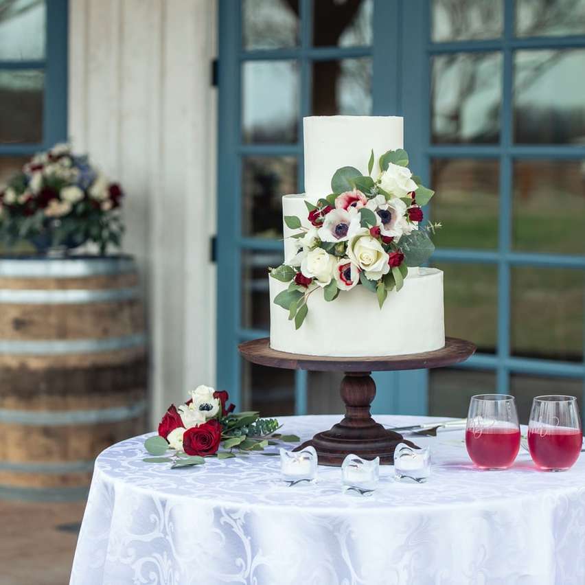 бело-розовый цветочный торт на коричневом деревянном круглом столе онлайн-пазл