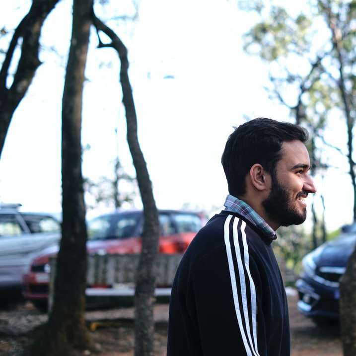 uomo in giacca bianco e nero in piedi vicino a alberi verdi puzzle scorrevole online