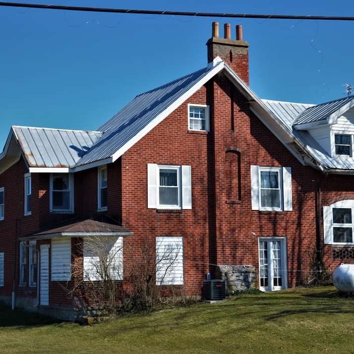 brązowy i biały betonowy dom pod błękitnym niebem w ciągu dnia puzzle przesuwne online