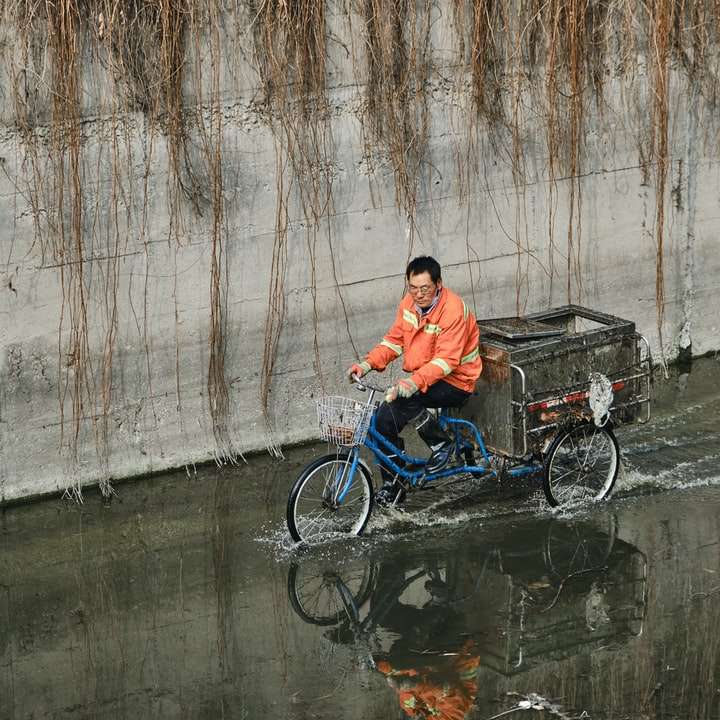 άντρας σε πορτοκαλί πουκάμισο πόλο ιππασία μπλε ποδήλατο συρόμενο παζλ online