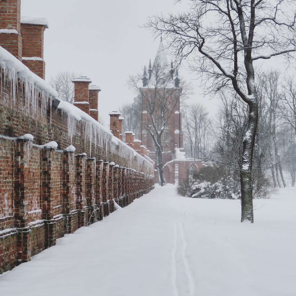 brauner Holzzaun mit Schnee bedeckt Schiebepuzzle online