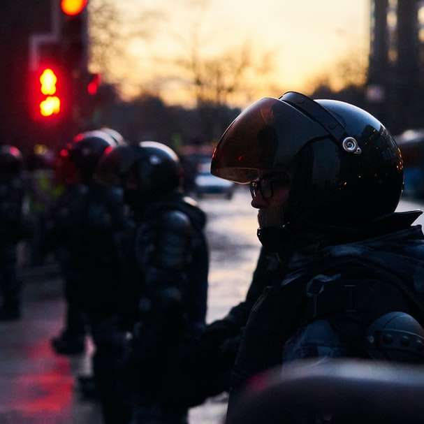 Menschen in schwarzer Jacke und Helm auf der Straße tagsüber Schiebepuzzle online