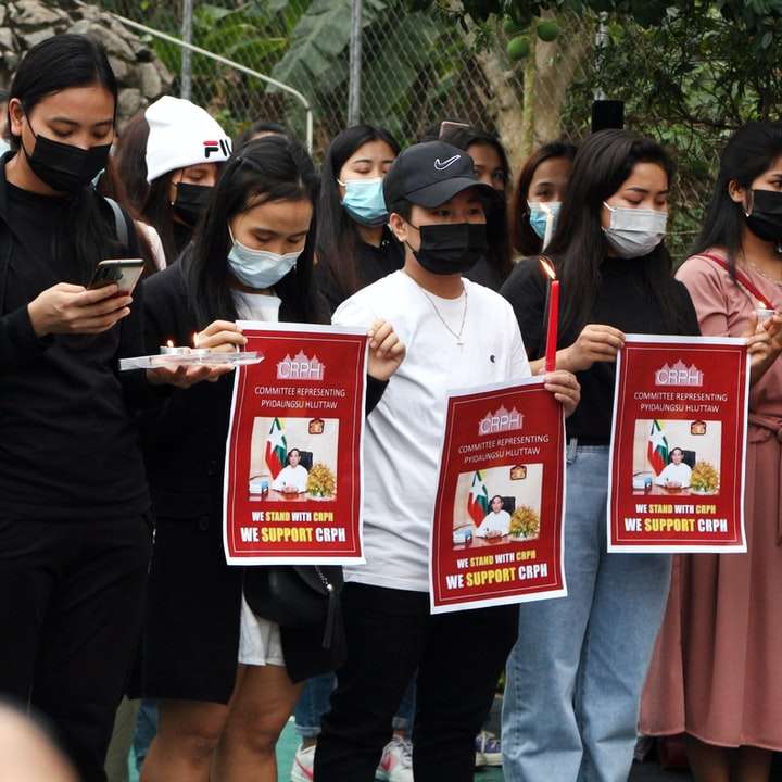 grupp människor som håller rött och vitt banner glidande pussel online