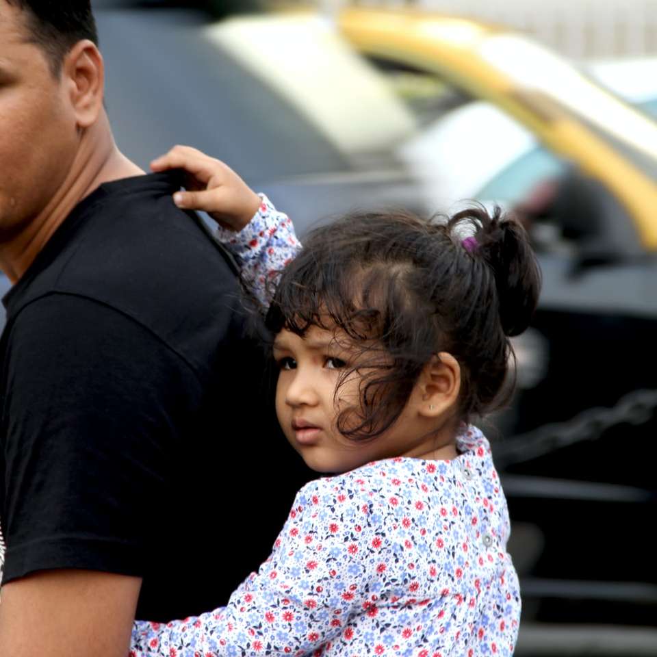 hombre en camiseta negra con niña rompecabezas en línea