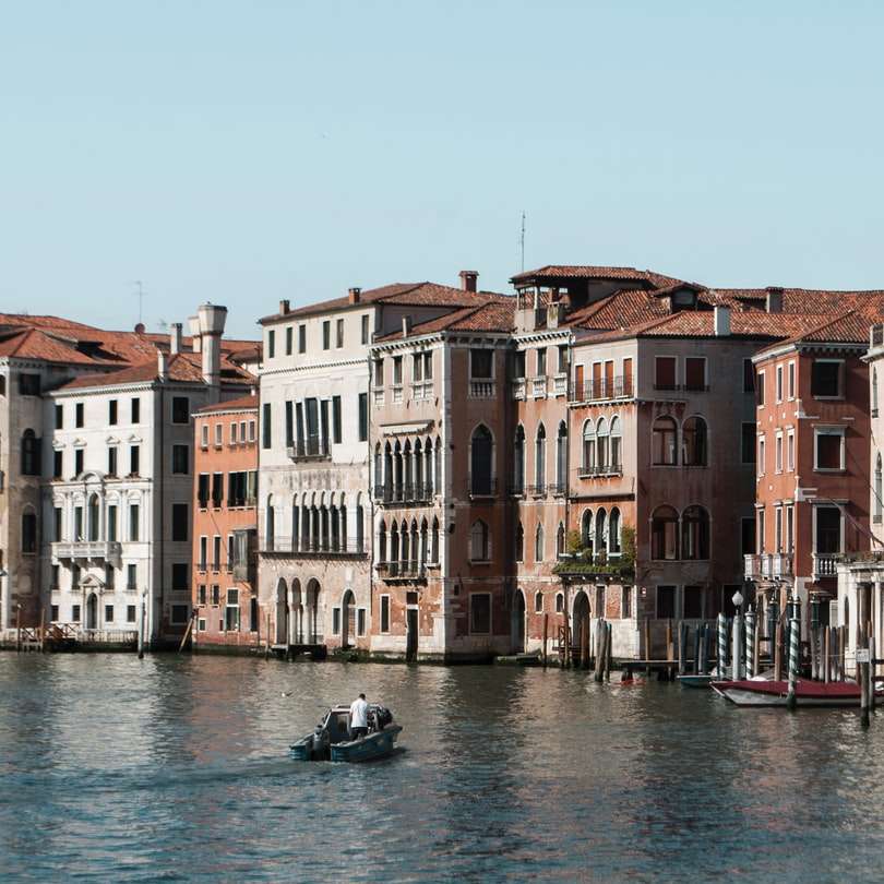 barca pe apă între clădiri în timpul zilei alunecare puzzle online