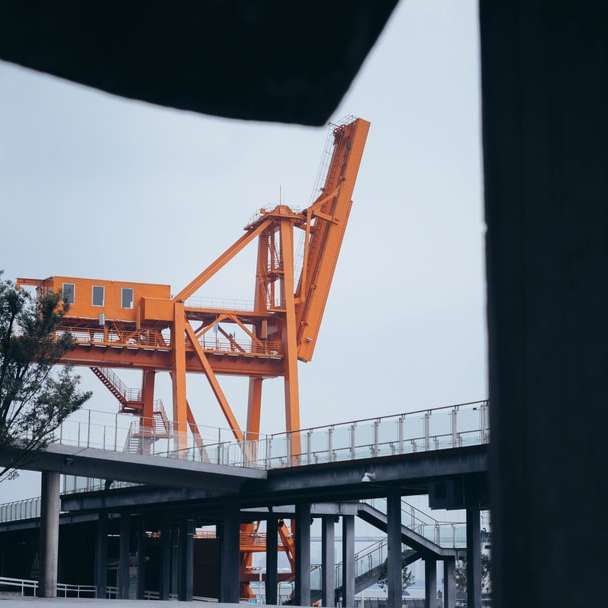 orange och svart kran nära byggnad under dagtid glidande pussel online