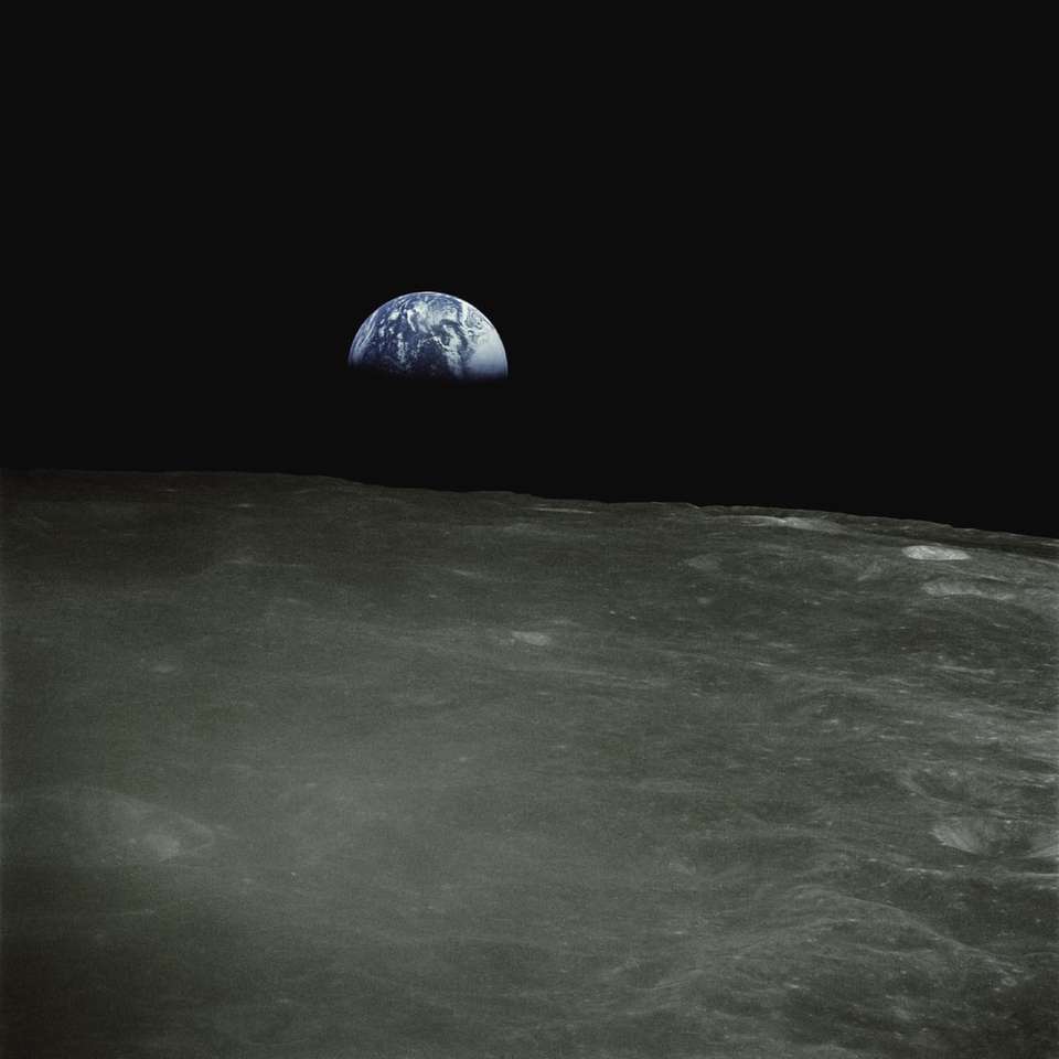 La Tierra se eleva por encima de la superficie lunar. puzzle deslizante online
