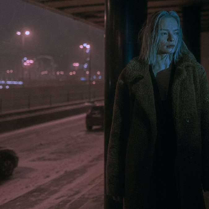 жінка в чорному пальті, стоячи на тротуарі в нічний час розсувний пазл онлайн