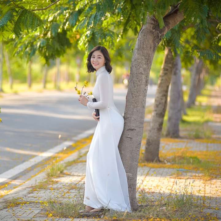 женщина в белом платье держит букет цветов онлайн-пазл