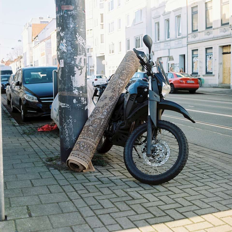 motocicletta rossa e nera parcheggiata accanto all'auto nera puzzle scorrevole online