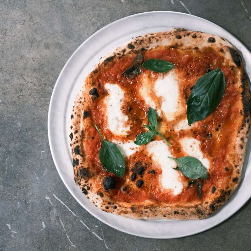 πίτσα με πράσινο φύλλο σε λευκό κεραμικό πιάτο online παζλ