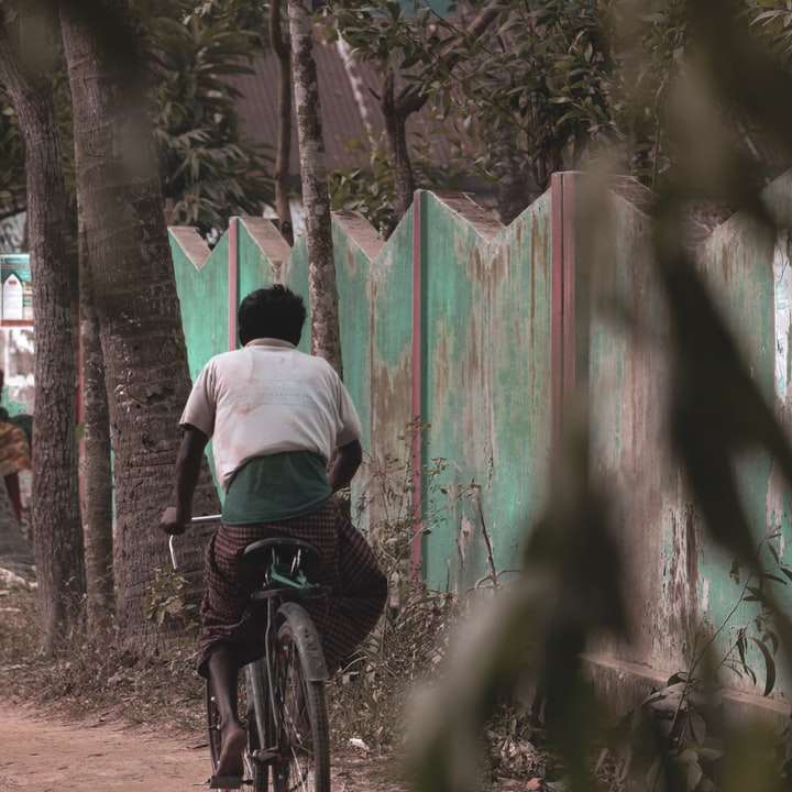 Hombre con camisa blanca montando bicicleta en el bosque puzzle deslizante online